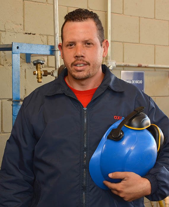 Homem com equipamento de EPIS nas mãos usando uma jaqueta da empresa Oxicam